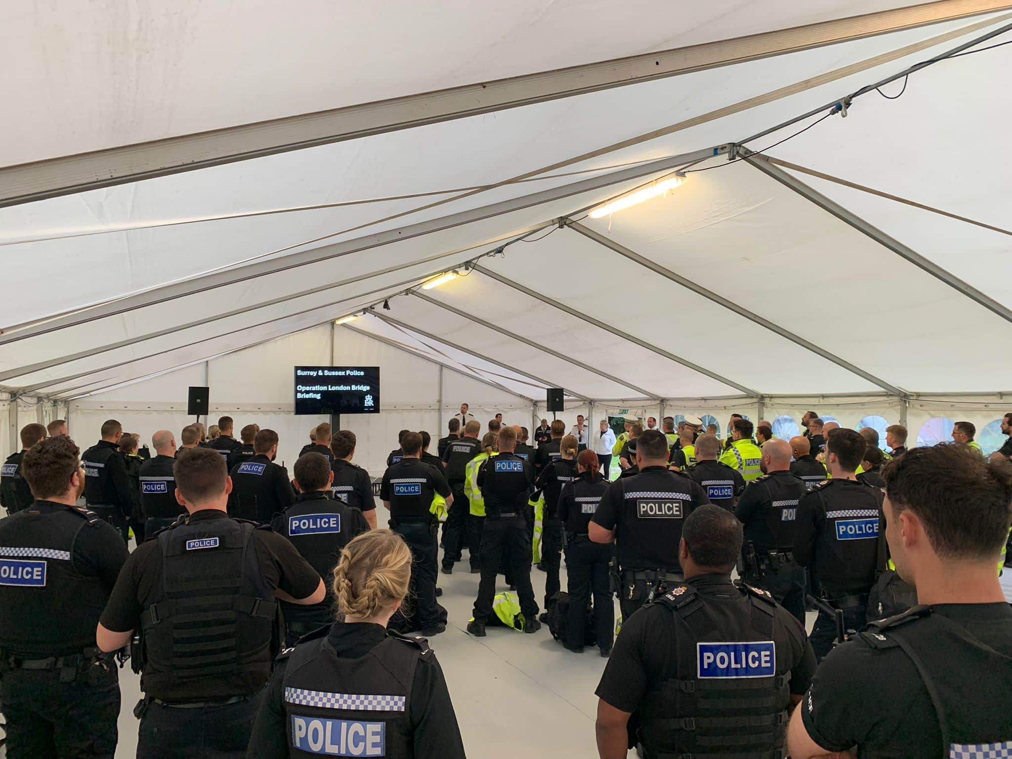 Un gran grupo de policías escuchando una sesión informativa.