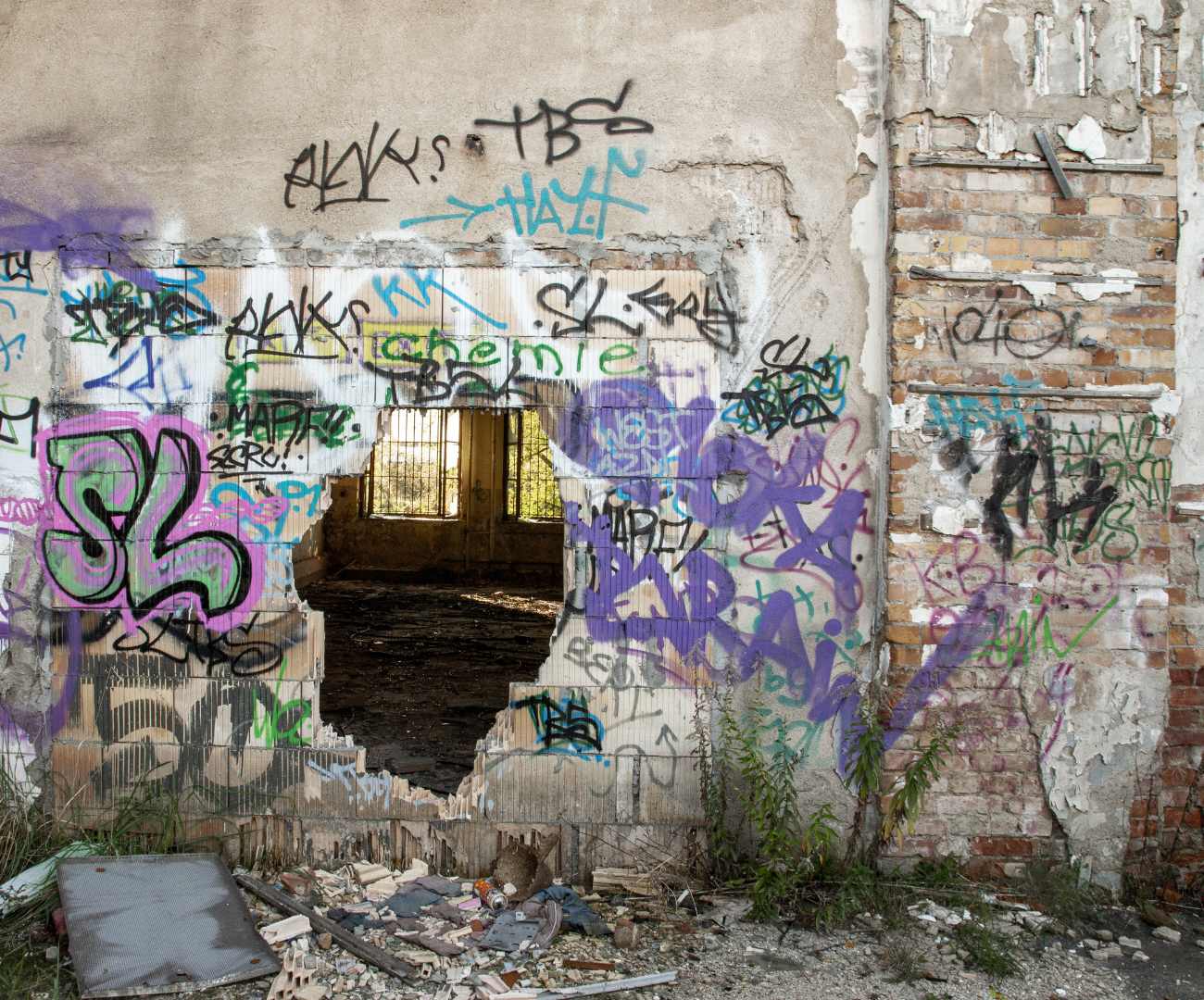 Graffiti and rubbish by wall