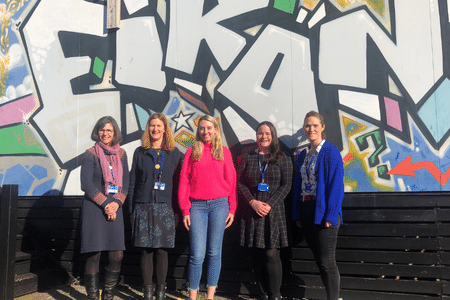 Deputy Commissioner Ellie Vesey-Thompson with representatives of Eikon Charity in front of graffiti wall with word Eikon