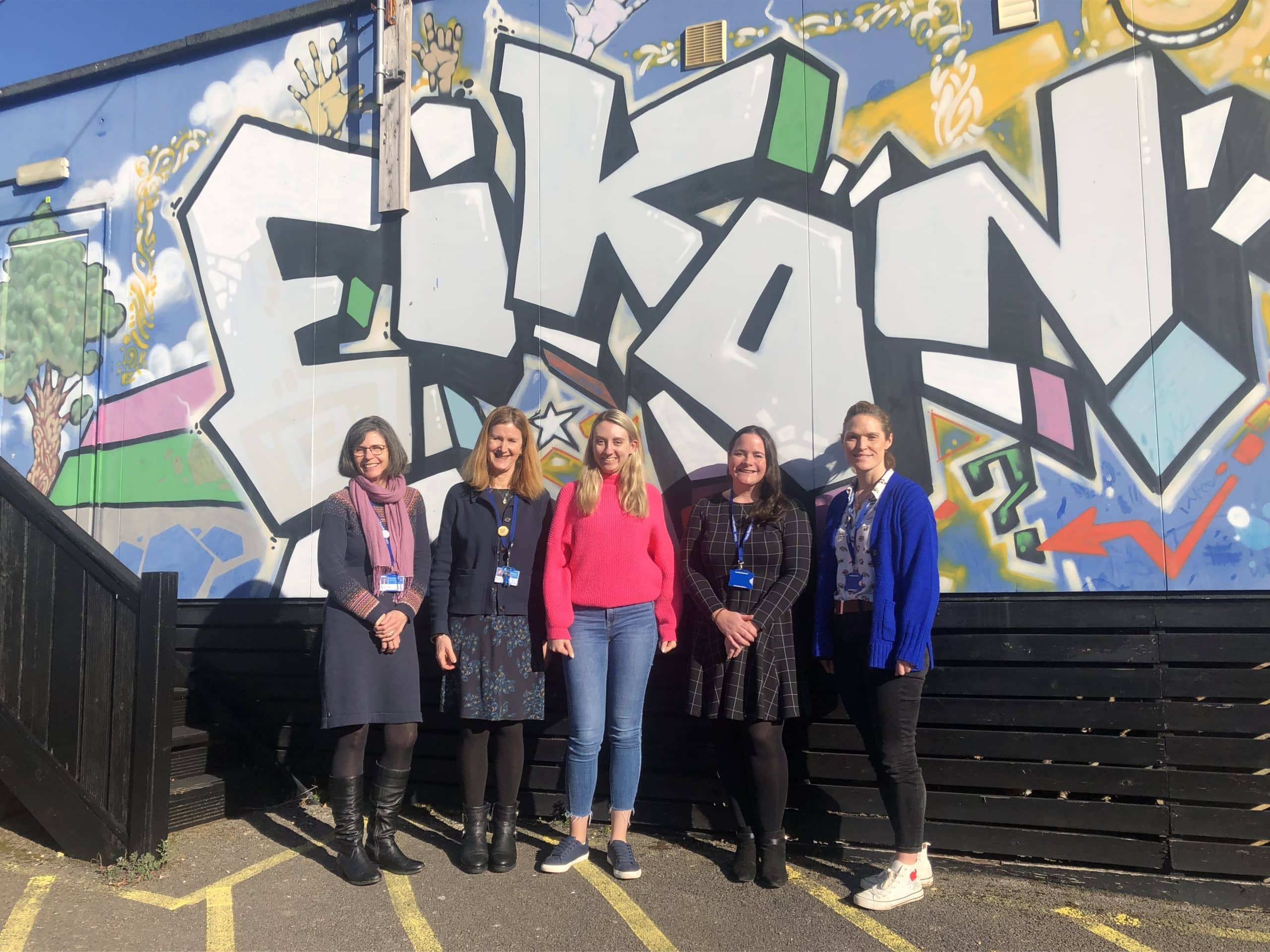 Deputy Commissioner Ellie Vesey-Thompson with representatives of Eikon Charity in front of graffiti wall with word Eikon