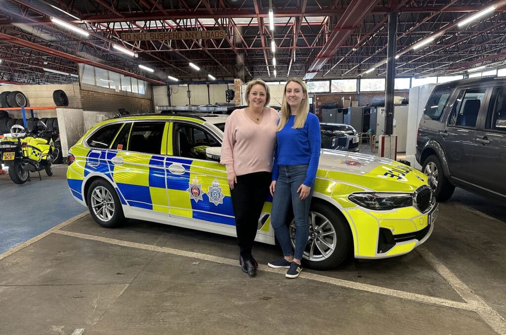 Police and Crime Commissioner Lisa Townsend and Deputy Police and Crime Commissioner Ellie Vesey-Thompson standing in front of a Surrey Police car