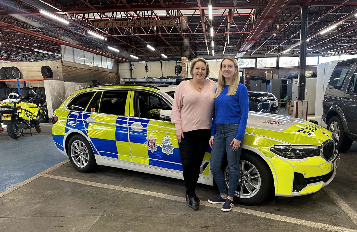 Police and Crime Commissioner Lisa Townsend and Deputy Police and Crime Commissioner Ellie Vesey-Thompson standing in front of a Surrey Police car