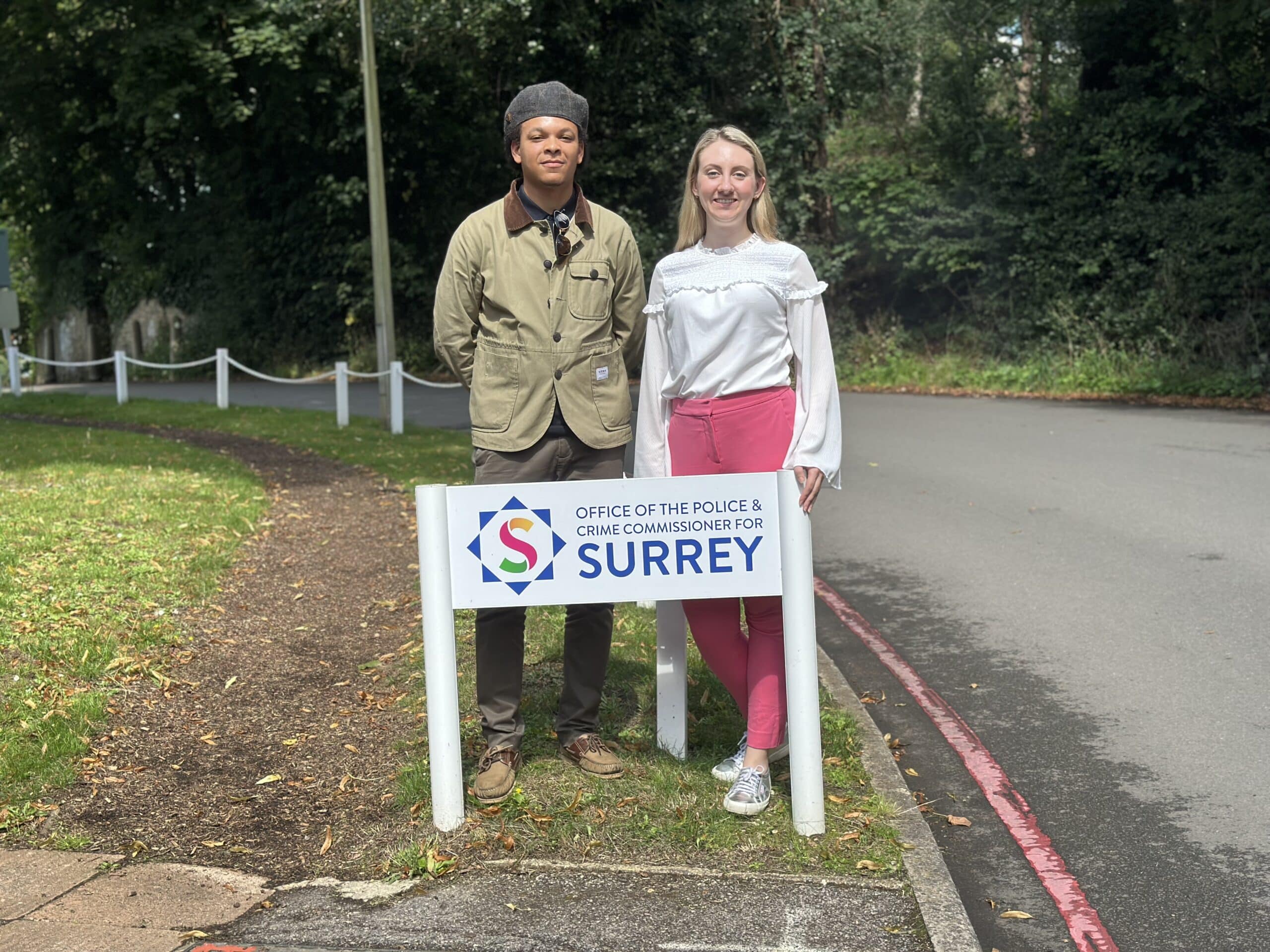 Deputy Commissioner Ellie Vesey-Thompson standing next to the sign for the Office of the Police and Crime Commissioner for Surrey, with the new young Crimestoppers Fearless worker Ryan Hines.