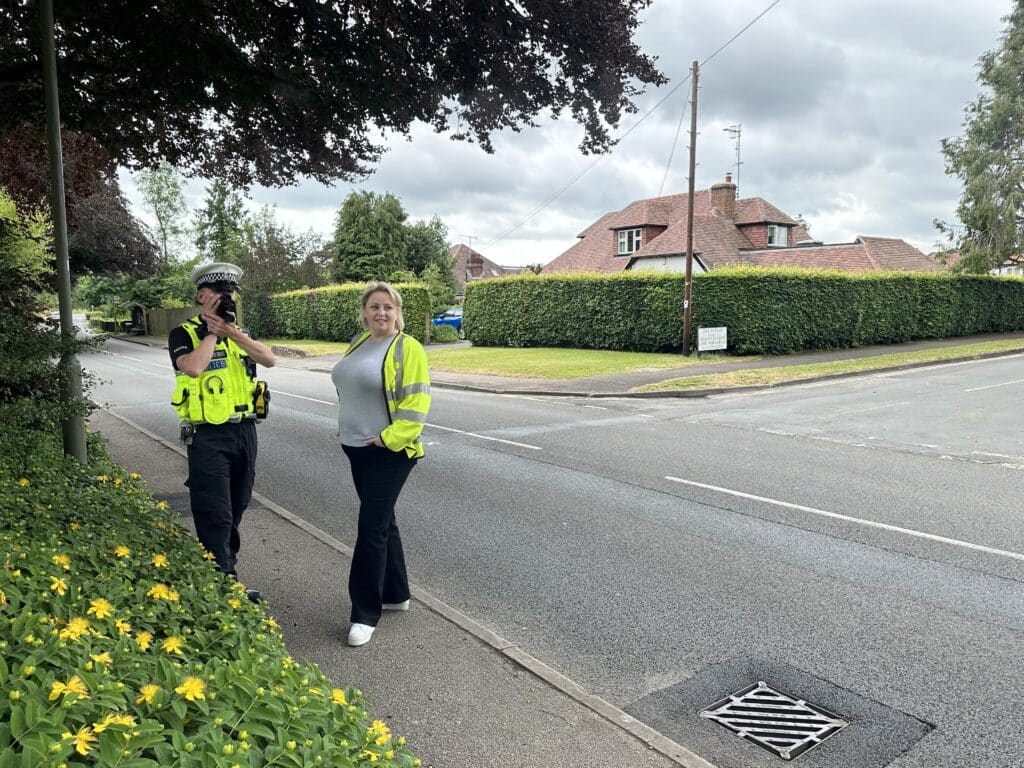 Police and Crime Commissioner for Surrey Lisa Townsend stands next to a roads safety police officer holding a speed gun