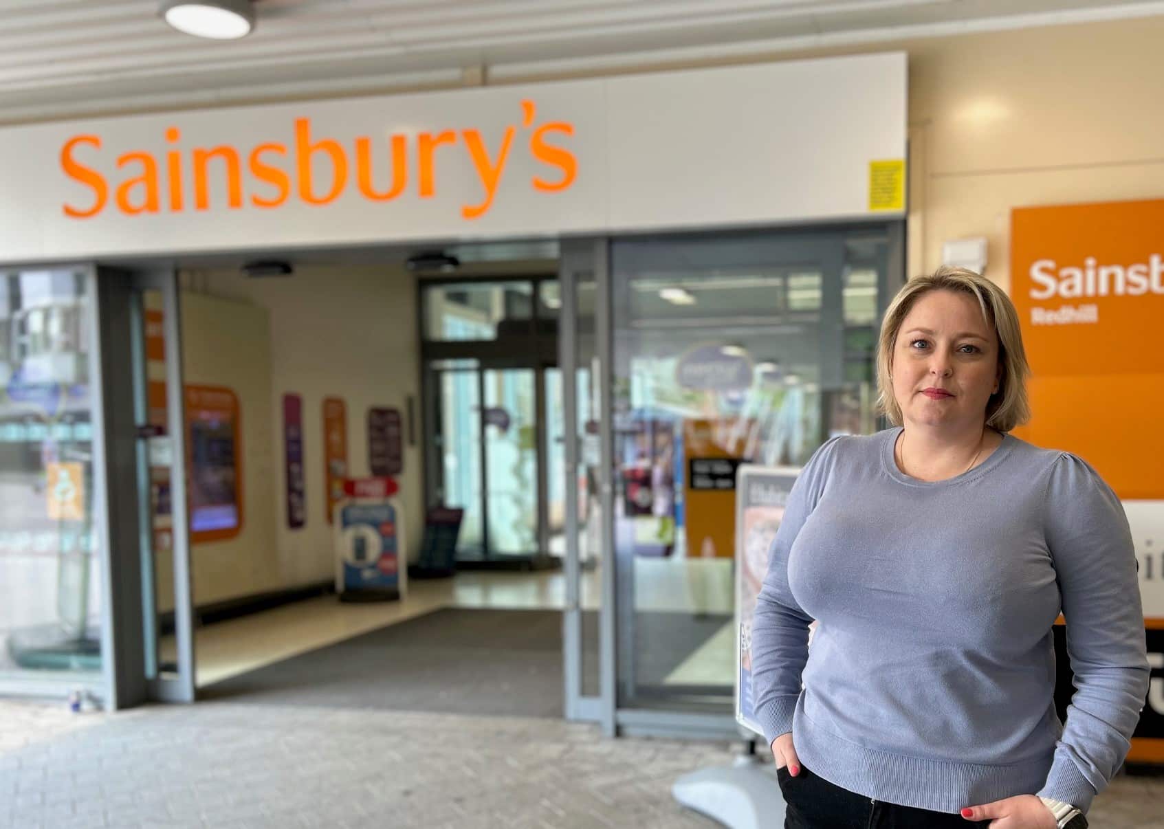 Police kaj Krimkomisaro Lisa Townsend starante ekster Sainsbury's en Redhill urbocentro