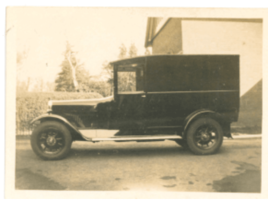Sepia image of the first police vehicle purchaed by Surrey Police in 1925 called the Bean Van.  The vehicle is the side view and black in colour